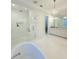 Bright bathroom features a modern tub, glass shower, vanity and chandelier at 4309 W Beachway Dr, Tampa, FL 33609