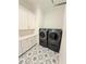 A spacious laundry room showcasing modern appliances and beautifully patterned tile flooring at 4309 W Beachway Dr, Tampa, FL 33609