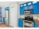 Modern kitchen featuring blue cabinets, stainless steel appliances, and wood counters at 265 Seahorse Se Dr # B, St Petersburg, FL 33705