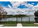 A lush backyard featuring a serene lake view and a black metal fence, blending nature and security at 9221 Mountain Magnolia Dr, Riverview, FL 33578