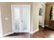 Entryway featuring light tan walls, white trim, hardwood floors, and double doors with decorative glass at 9221 Mountain Magnolia Dr, Riverview, FL 33578