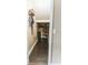 Hallway leading to a possible storage room with dark wood flooring, white trim, and neutral paint at 9221 Mountain Magnolia Dr, Riverview, FL 33578