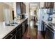 Open kitchen boasts granite countertops, stainless appliances, and dark cabinetry for a modern aesthetic at 9221 Mountain Magnolia Dr, Riverview, FL 33578