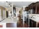 Spacious kitchen with dark cabinets, granite countertops, stainless steel appliances, and view to the dining area at 9221 Mountain Magnolia Dr, Riverview, FL 33578