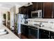 Modern kitchen featuring stainless steel appliances, granite countertops, and dark cabinets at 9221 Mountain Magnolia Dr, Riverview, FL 33578