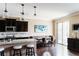 Open kitchen with granite countertops, dark cabinets, breakfast bar, and dining area with large windows at 9221 Mountain Magnolia Dr, Riverview, FL 33578