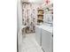 Well-organized laundry room with floral accents, including a washer, dryer, and shelving at 9221 Mountain Magnolia Dr, Riverview, FL 33578