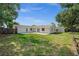 Expansive backyard view showcasing the home's exterior, patio area, and surrounding greenery at 2126 Hanby St, Port Charlotte, FL 33952