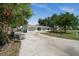 Well-maintained single-story home with a spacious driveway and lush green surroundings at 2126 Hanby St, Port Charlotte, FL 33952