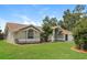 Side view of a single Gathering home featuring lush green grass and mature trees at 4266 Candler Ave, Spring Hill, FL 34609