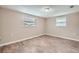 Light-filled bedroom with wood-look floors, two windows, and neutral paint at 5429 Flora Ave, Holiday, FL 34690