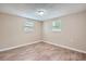 A bright bedroom features wood-look floors, two windows, and neutral paint at 5429 Flora Ave, Holiday, FL 34690