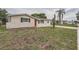 Charming home featuring a well-maintained lawn, traditional shutters, and a vibrant red front door at 5429 Flora Ave, Holiday, FL 34690
