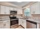Modern kitchen with stainless steel appliances, granite countertops, and white cabinetry at 5429 Flora Ave, Holiday, FL 34690