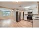 Open concept kitchen with stainless steel refrigerator flowing into the dining and living area at 5429 Flora Ave, Holiday, FL 34690