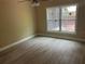 Cozy bedroom featuring modern flooring, a large window, and neutral wall paint at 12421 Early Run Ln, Riverview, FL 33578