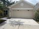 Spacious two-car garage featuring decorative windows and updated exterior lighting at 12421 Early Run Ln, Riverview, FL 33578