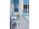 Balcony with outdoor seating, white chairs with blue stripes, and gray flooring at 215 Medallion Blvd # G, Madeira Beach, FL 33708