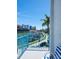 Balcony view with turquoise railings, overlooking docked boats, waterfront, and nearby hotels on a sunny day at 215 Medallion Blvd # G, Madeira Beach, FL 33708
