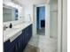 Bright bathroom features a blue vanity with white countertops and marble floors at 215 Medallion Blvd # G, Madeira Beach, FL 33708
