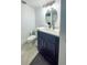 Modern bathroom with a blue vanity, white countertops, and an oval mirror at 215 Medallion Blvd # G, Madeira Beach, FL 33708