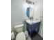 Modern half bath with blue vanity, white countertop, and modern fixtures, ideal for guests at 215 Medallion Blvd # G, Madeira Beach, FL 33708