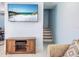 Comfortable living room features a television, cabinet, and staircase at 215 Medallion Blvd # G, Madeira Beach, FL 33708