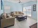 Stylish living room featuring marble floors, neutral furniture, and large picture windows overlooking water at 215 Medallion Blvd # G, Madeira Beach, FL 33708