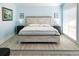 Well-lit main bedroom features a rustic bed frame and hardwood floors at 215 Medallion Blvd # G, Madeira Beach, FL 33708