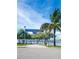 View of the R.O.C. Park entrance, with palm trees, mature trees, and a glimpse of the water at 215 Medallion Blvd # G, Madeira Beach, FL 33708