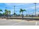 View of community tennis court with new fencing in a parking area, surrounded by palm trees on a sunny day at 215 Medallion Blvd # G, Madeira Beach, FL 33708