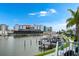 A waterfront view showing docked boats, a landscaped walkway, and nearby hotels on a sunny day at 215 Medallion Blvd # G, Madeira Beach, FL 33708