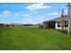 Large backyard with green grass and partial view of the home and a screened in patio at 3142 Torta Ct, Bradenton, FL 34211