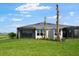 Backyard view of a house, featuring green grass, trees, and a screen patio at 3142 Torta Ct, Bradenton, FL 34211