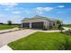 Home exterior featuring a two-car garage and driveway with professional landscaping at 3142 Torta Ct, Bradenton, FL 34211