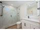 Modern bathroom features glass shower, white cabinets, matte black hardware and quartz counters at 5108 Saint Albans Ave, Siesta Key, FL 34242