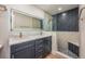 Updated bathroom with double sinks, illuminated mirror, and walk-in shower featuring herringbone tiling at 5108 Saint Albans Ave, Siesta Key, FL 34242