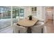 Light-filled dining area with a modern wood table and seating, adjacent to the outdoor pool view at 5108 Saint Albans Ave, Siesta Key, FL 34242