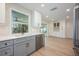 Bright kitchen features gray cabinetry, stainless steel appliances, marble backsplash and hardwood flooring at 5108 Saint Albans Ave, Siesta Key, FL 34242