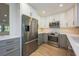 Modern kitchen featuring stainless steel appliances, updated cabinetry, and stylish countertops with wood flooring at 5108 Saint Albans Ave, Siesta Key, FL 34242