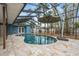 Screened-in pool area with travertine tile, covered seating, and views of the landscaped backyard at 5108 Saint Albans Ave, Siesta Key, FL 34242