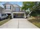 View of the home's garage and driveway with ample storage space inside and a manicured lawn outside at 10124 Westpark Preserve Blvd, Tampa, FL 33625