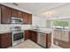 Modern kitchen with stainless steel appliances and granite countertops, seamlessly connecting to the bright living space at 10124 Westpark Preserve Blvd, Tampa, FL 33625