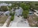 Aerial view of a charming home with a well-manicured lawn and lush landscaping near a tranquil waterfront at 135 Florida Blvd, Crystal Beach, FL 34681