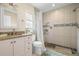 Bathroom featuring decorative tiled shower, updated vanity, and earth-toned color palette at 135 Florida Blvd, Crystal Beach, FL 34681