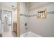 Shower and tub featuring decorative tiles and built-in shelving, designed for relaxation and convenience at 135 Florida Blvd, Crystal Beach, FL 34681