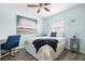 Comfortable bedroom with coastal artwork, a ceiling fan, and a convenient desk space for work or study at 135 Florida Blvd, Crystal Beach, FL 34681