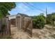 Outdoor shed with fence surround; perfect for storage and matches the aesthetic of the home at 135 Florida Blvd, Crystal Beach, FL 34681