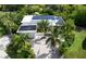 Aerial view of a modern home featuring solar panels, lush landscaping, and a paver driveway at 2408 Nassau St, Sarasota, FL 34231