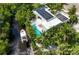Aerial view of modern home with solar panels, pool, boat dock, and lush landscaping at 2408 Nassau St, Sarasota, FL 34231